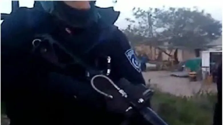 Policeman aims before firing at Havat Gilad.