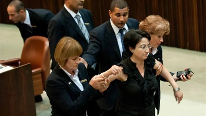 Guards escort Zoabi out of the Knesse