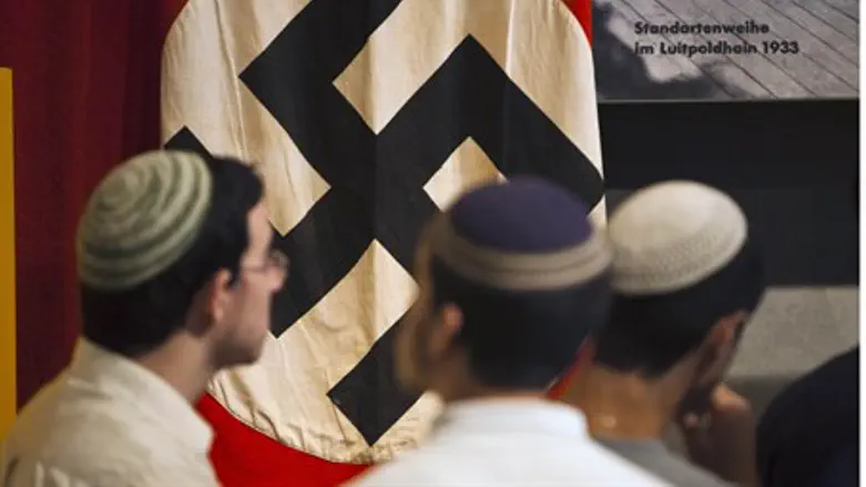Jews stand in front of swastika at Yad Vashem