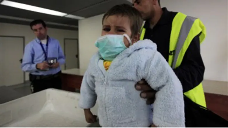 Sick Arab child, father at Gaza crossing.