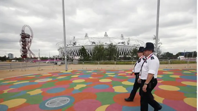 Police officers walk past the Olympic Stadium