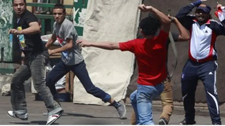Supporter of Morsi (in red) clashes with anti