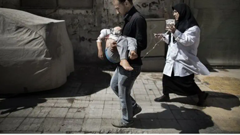 A Syrian man carries his wounded daughter in 