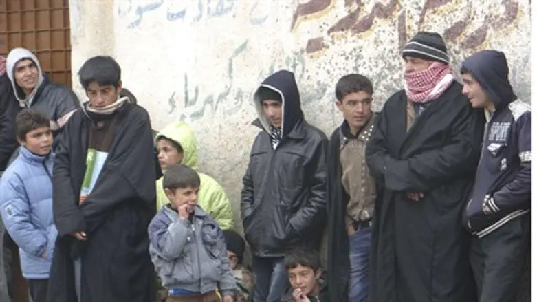 Syrians wait in line to buy bread
