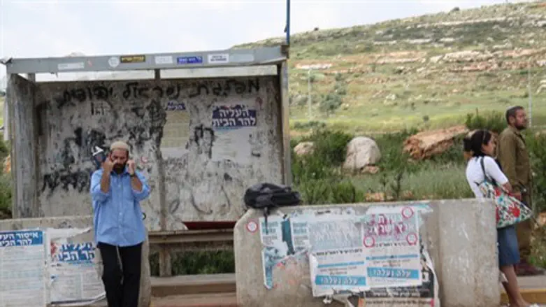 Israeli hitchhiker waits for a ride in Samari