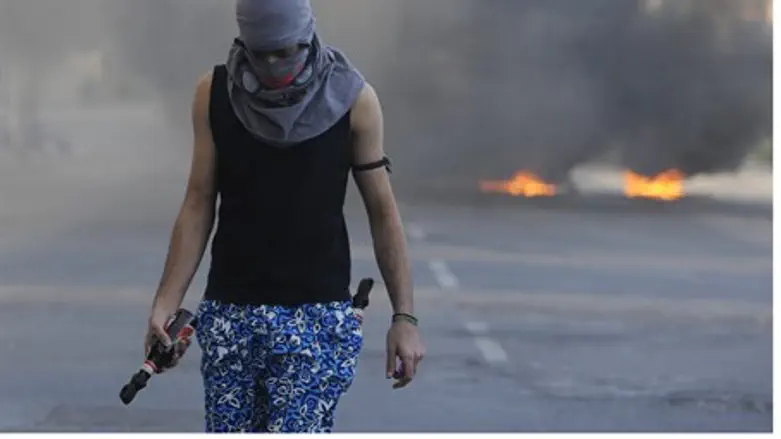 Bahraini protester west of Manama holds fireb