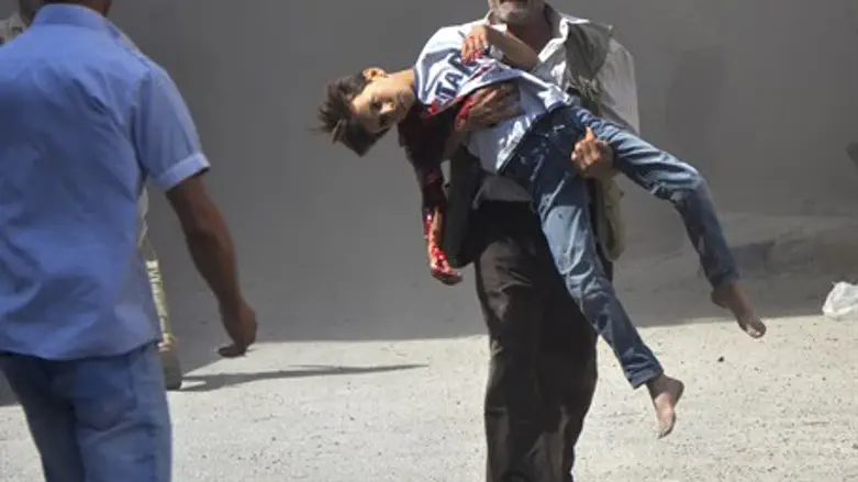 Syrian man carries wounded boy