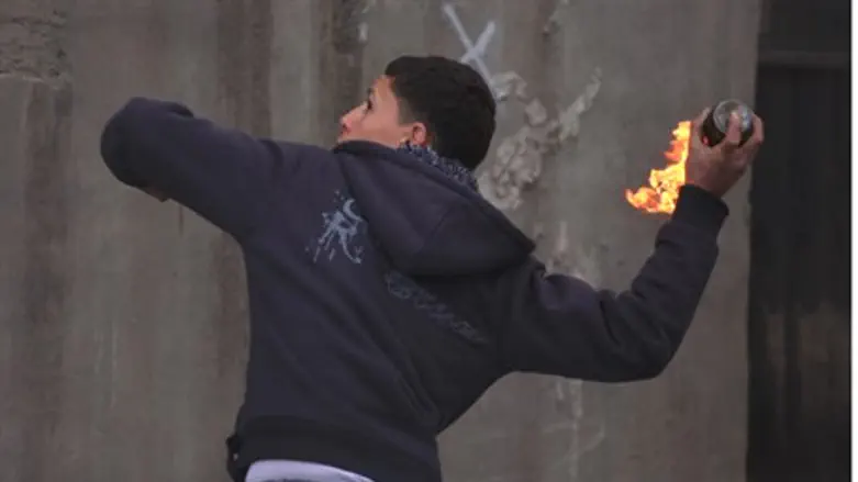 Arab youth hurls a firebomb during anti-Israe