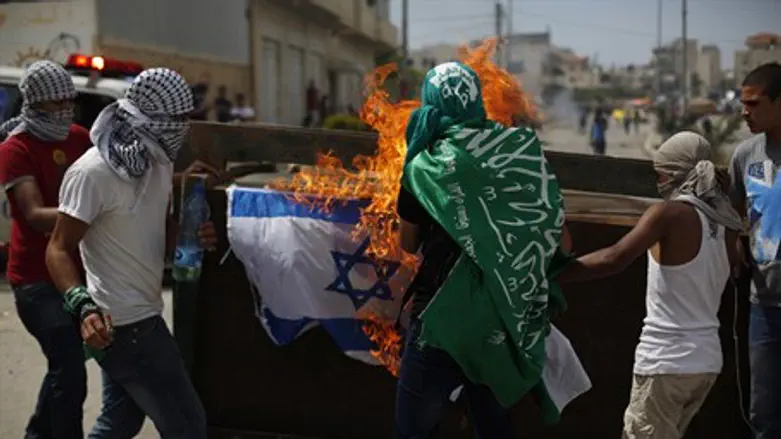 Protesters burn an Israeli flag during clashe