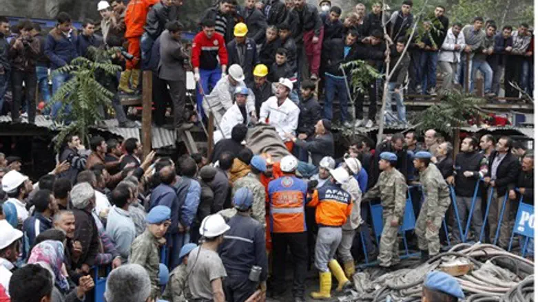 Rescuers carry a miner who sustained injuries
