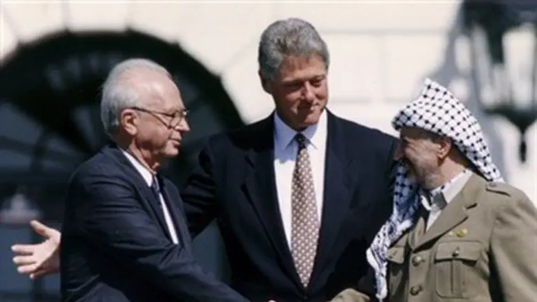 Yitzhak Rabin and Yasser Arafat shake hands at the signing of the Oslo Accords