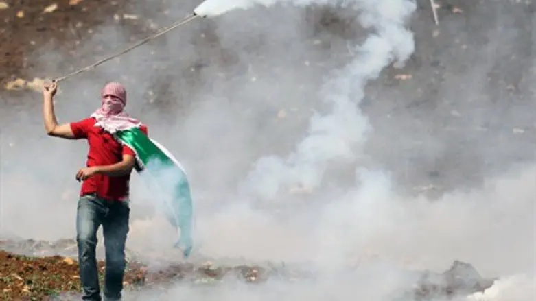 Arab rioter lobs tear gas on 'Nakba Day'