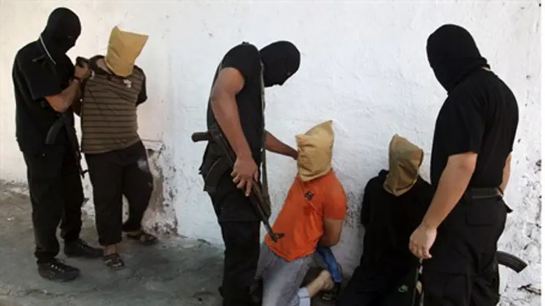 Hamas gunmen prepare three men for execution 