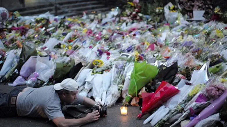Visitor lights a candle at memorial to Sydney attack victims