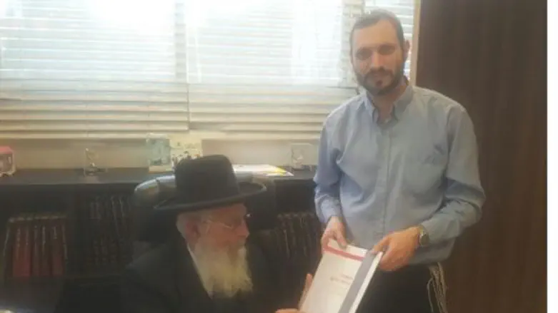 Rabbi Ariel receives brochure from Rabbi Amital Bareli