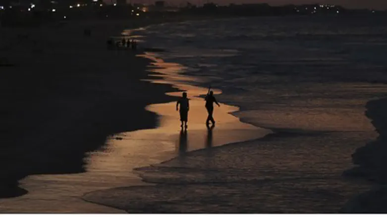 Palestinian Arab fishermen walk along the beach of Gaza City