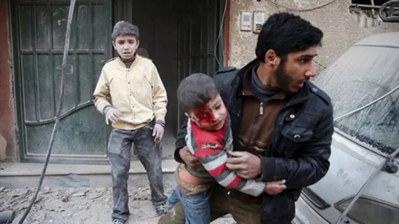Syrian man carries boy injured by regime shelling (illustration)