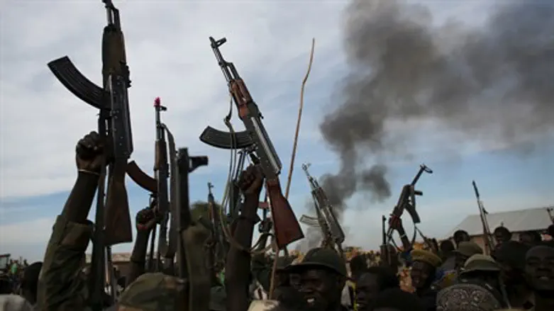 Rebel fighters in Sudan holding up rifles