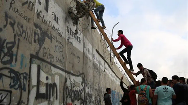 Arabs climb over Jerusalem security barrier (file)
