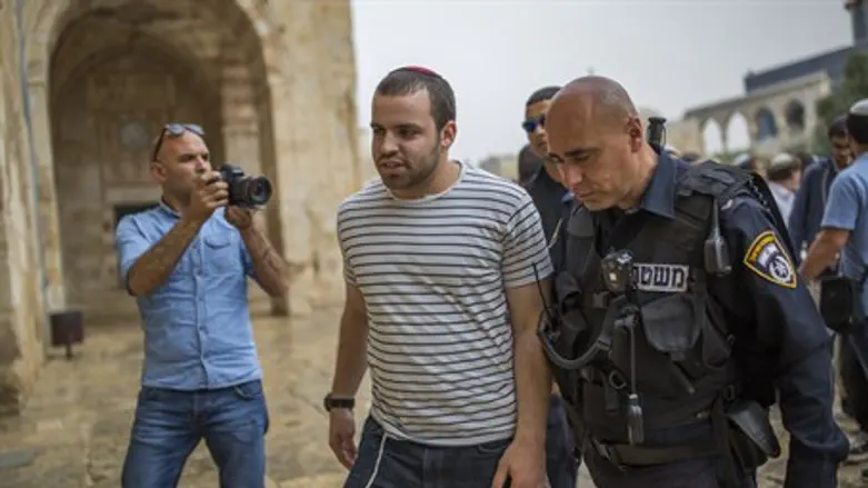 A Waqf guard (L) monitors Jewish visitors to the Temple Mount, accompanied by Israeli poli
