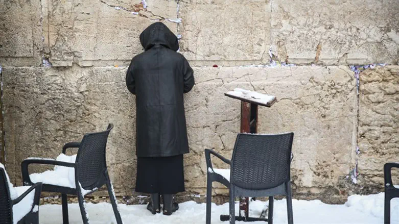 Woman prays at Kotel in winter