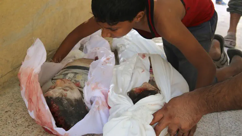 A Syrian boy mourns his brother and sister after they were killed during fighting in Alepp