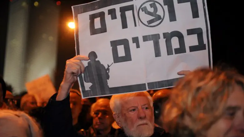 Uri Avnery holds a sign calling IDF soldiers 'murderers'