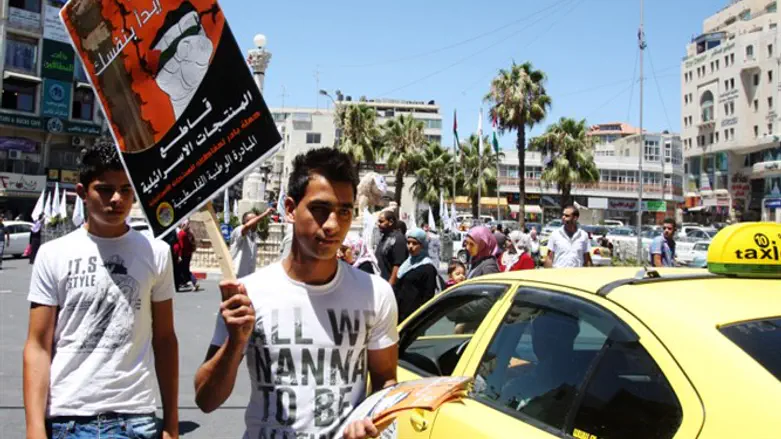 Man waves pro-boycott sign in Ramallah