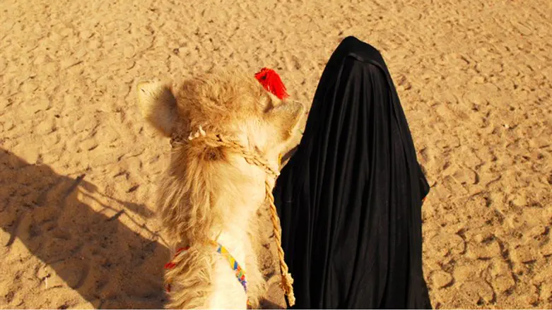 Bedouin woman (right) with camel (left).