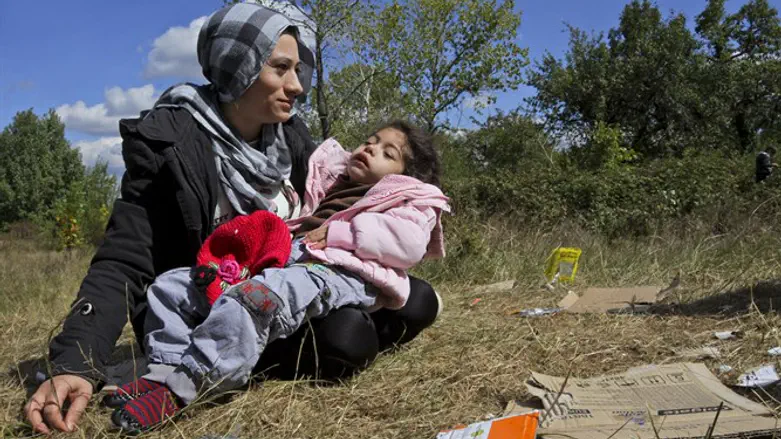 Syrian mother holds her sick child