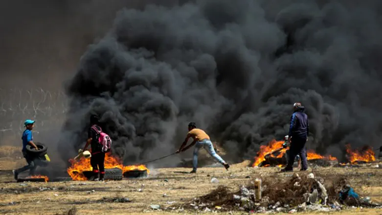 Arab rioters hurl flaming tires at Israel's fence along Gaza border