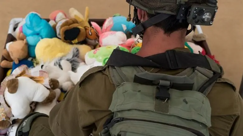 IDF soldier carrying stuffed toys for Syrian children