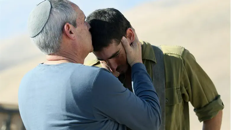 Father kisses soldier son