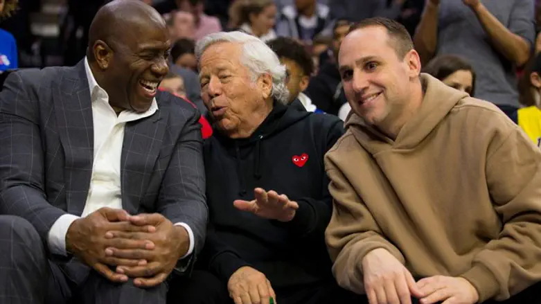 Magic Johnson, Robert Kraft, and Michael Rubin sit next to each other during a game