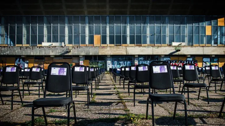 Chairs with fake money next to decaying Palace of Concerts & Sports of Vilnius