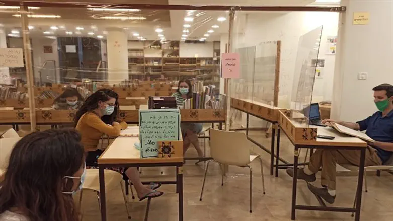 Students at Nishmat in Jerusalem wear masks and are separated by Plexiglas barri