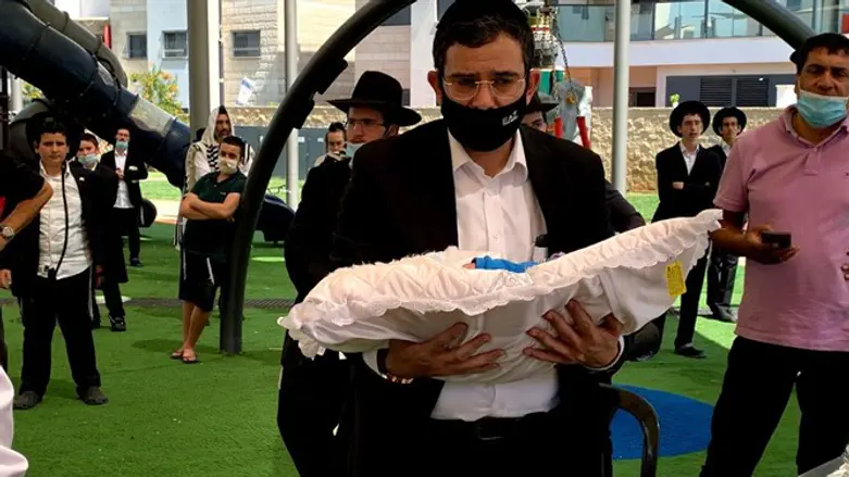 Rabbi Moshe Cohen carrying the baby