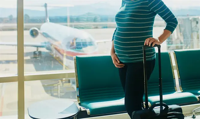 Беременная женщина в аэропорту. Иллюстрация